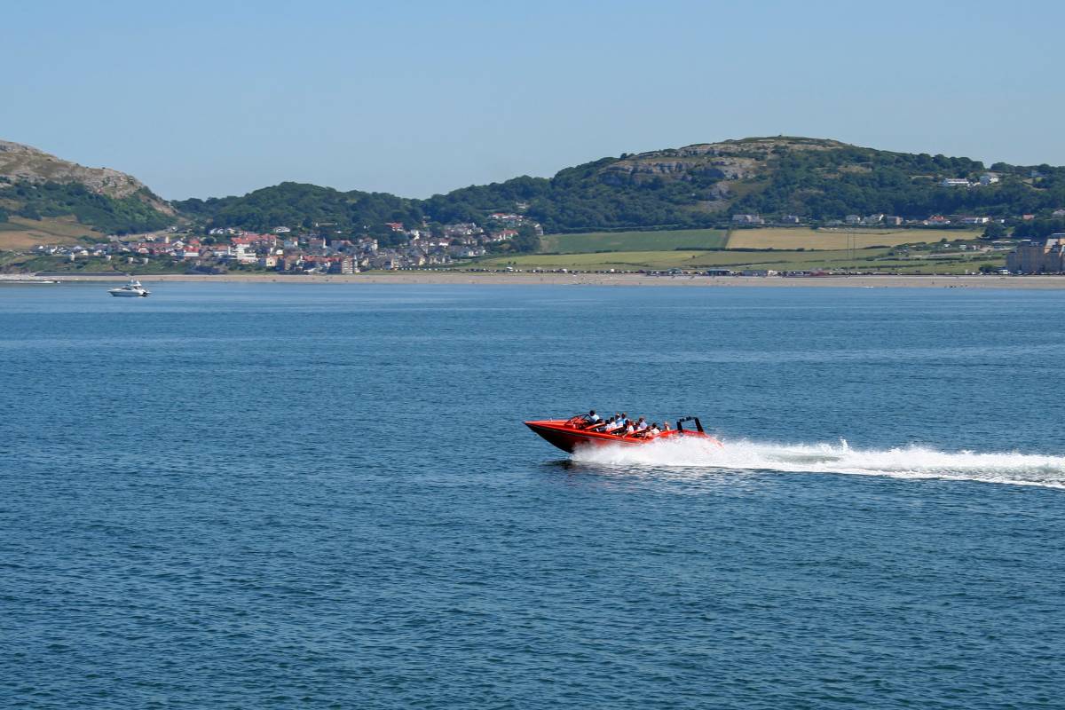 Speed boat full of tourists drives through Llandudno bay